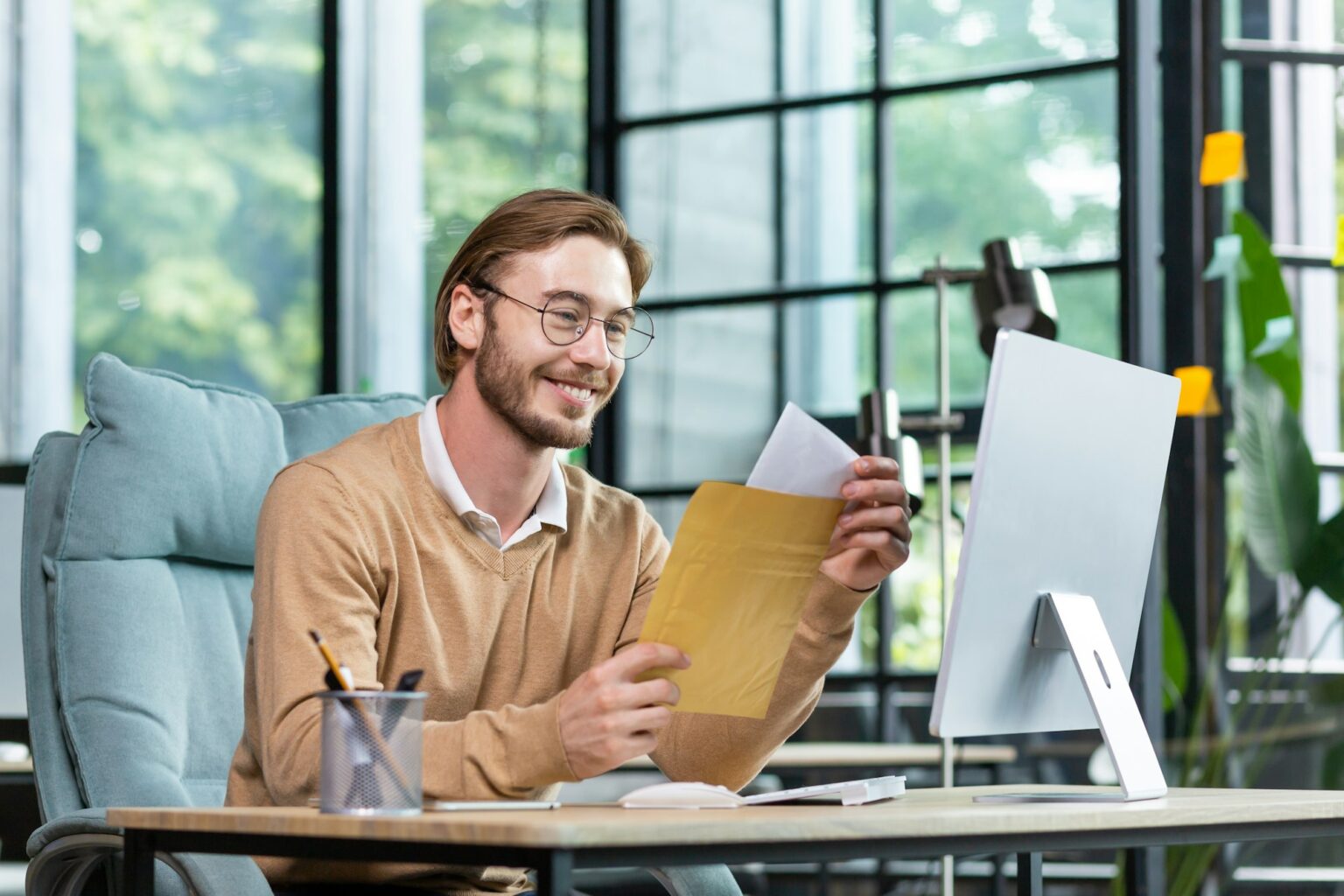 Comment savoir si un recommandé a été reçu ? Guide complet Young successful businessman in casual interior of office, blond man reading postal letter with