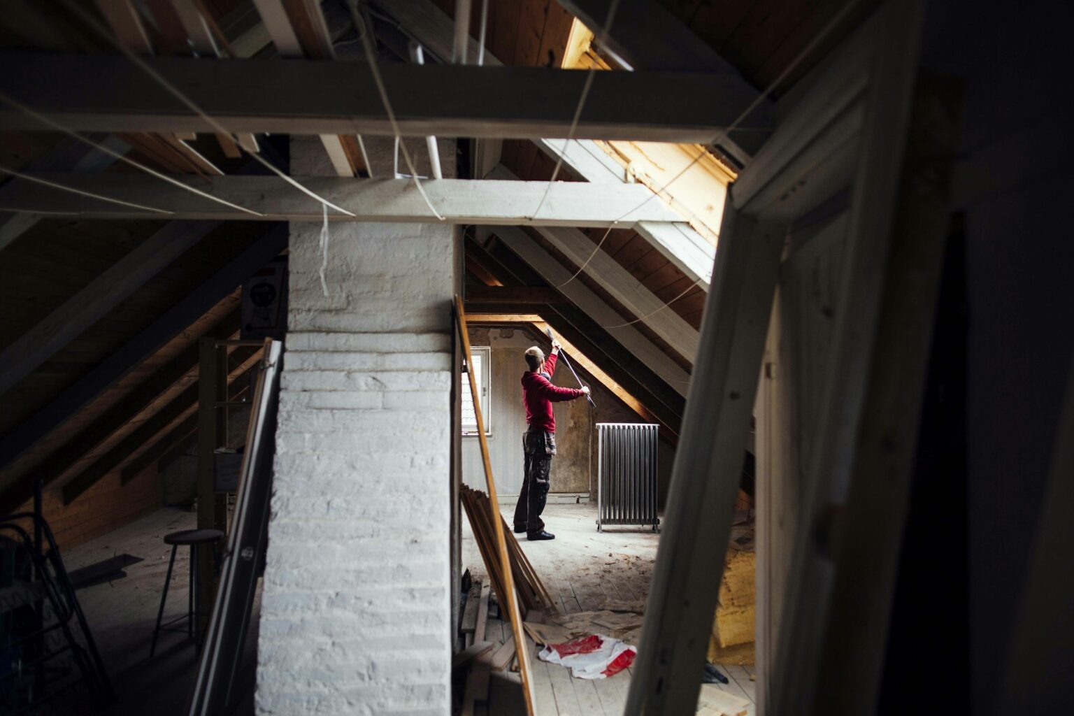 Rangement du grenier : astuces et conseils pour optimiser cet espace Person renovating an attic space