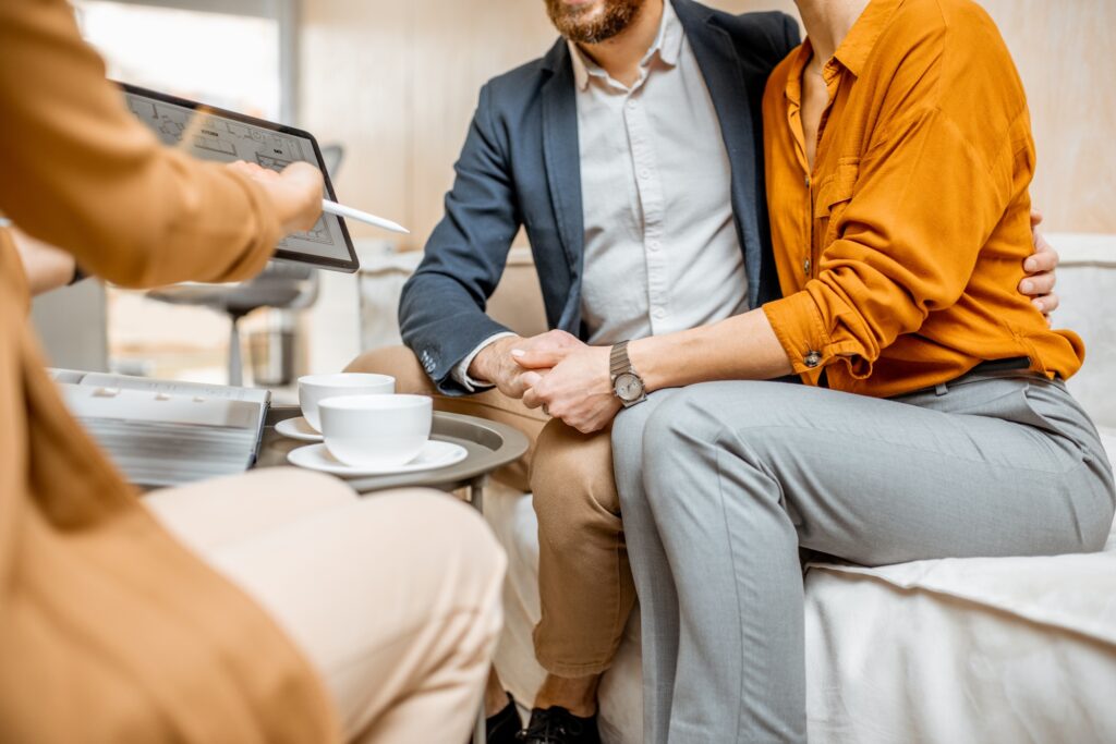 Young couple choosing house at the real estate agency
