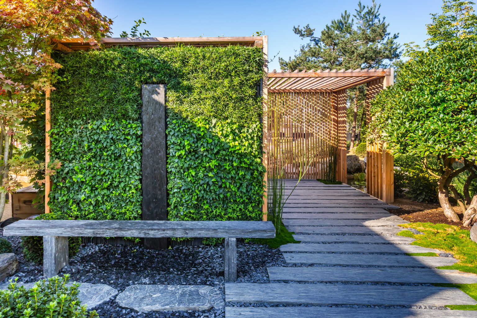 Nettoyer une terrasse en ardoise : guide des produits et méthodes efficaces Conifer and slate path with bark mulch and native plants in Japanese garden.