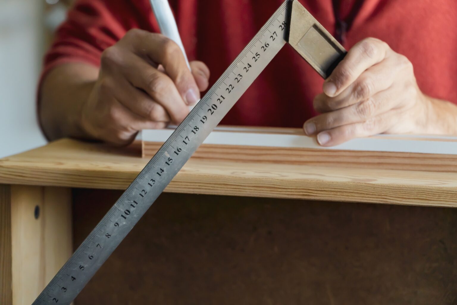 Calculateur de volume : simulation, méthode et conseils pour vos travaux closeup of a carpenter's hand measuring with a traditional ruler